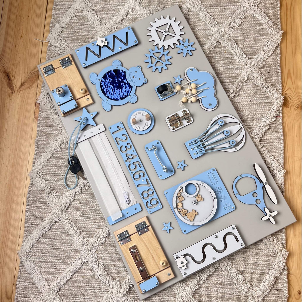 Activity board s dvířky a zámky BusyBunnyToys 40 × 60 cm, světle modré provedení, pohled shora