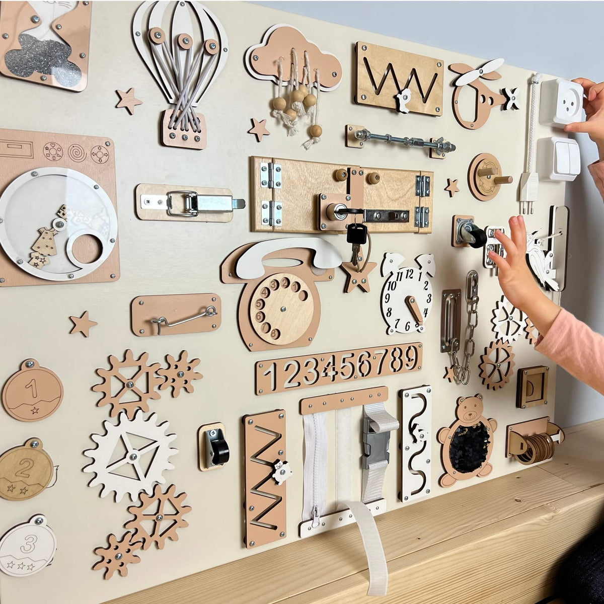 Dítě si hraje s extra velkým activity boardem na zeď BusyBunnyToys 60 × 80 cm, béžové provedení